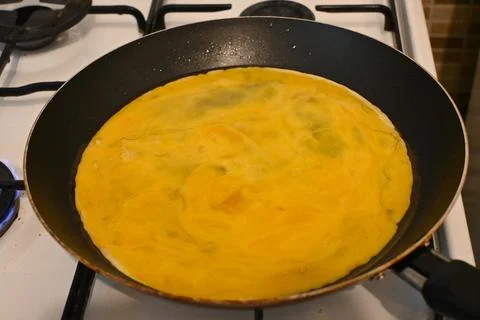 Scrambled eggs cooking in a frying pan Stockfoto's