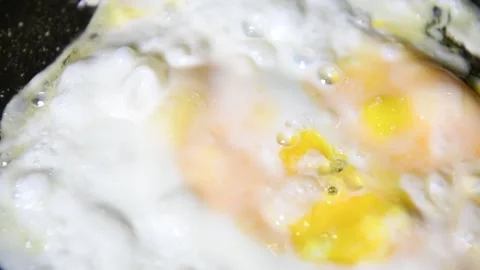 Scrambled eggs cooking. One egg being fried on a frying pan Stock Footage 140029829