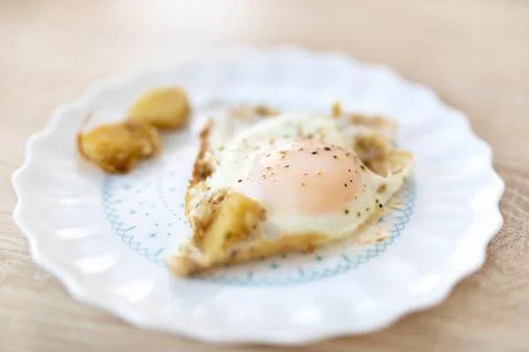 Scrambled eggs. Fried eggs with potato cubes on the plate Stock Photos