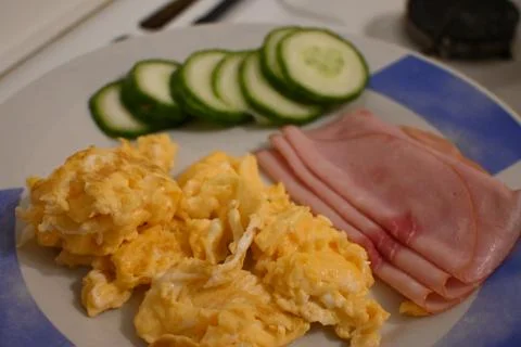 Scrambled eggs with ham and cucumber Stockfoto's