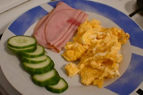 Scrambled eggs with ham and cucumber Fotos Stock