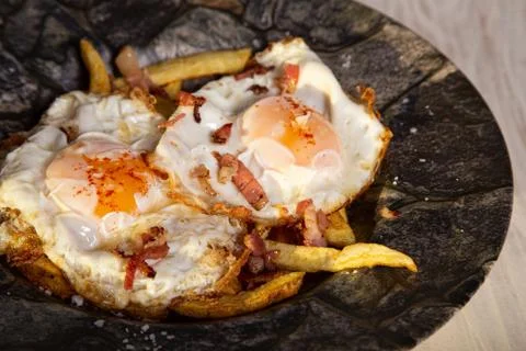 Scrambled eggs with ham and fried potatoes. spanish cuisine. Stock Photos