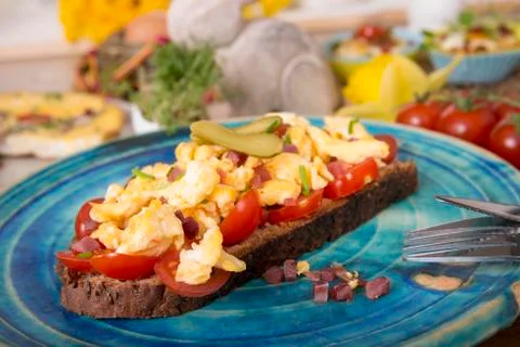 Scrambled eggs with ham cubes on protein bread with tomatos and Easter Foto stock