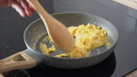 Scrambled eggs, omelette. Cooking breakfast with pan-fried eggs. Preparing food Stock Footage 150452018
