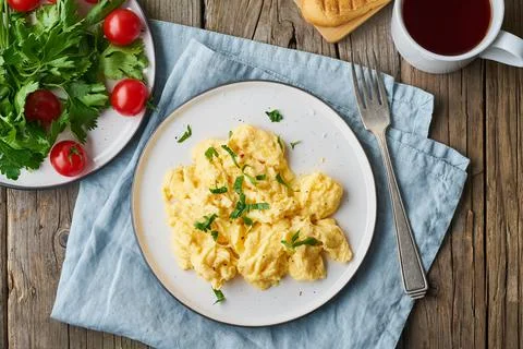 Scrambled eggs, omelette, side view. Breakfast with pan-fried eggs Stock Photos
