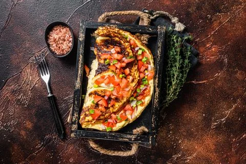 Scrambled eggs omelette with tomatoes, red bell pepper and onion. Dark Stock Photos