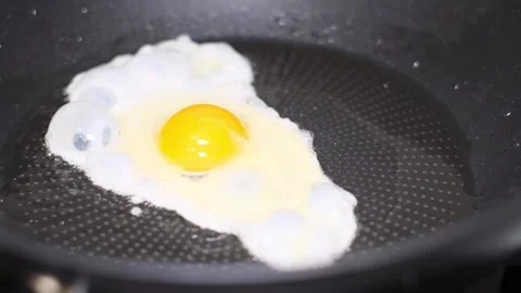 Scrambled eggs in a pan. A broken egg. Cooking concept Stock-Footage 253079462
