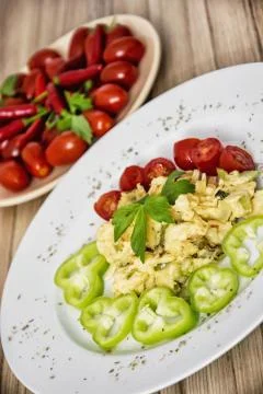 Scrambled eggs with paprika, cherry tomatoes and celery leaves, food theme 스톡 사진