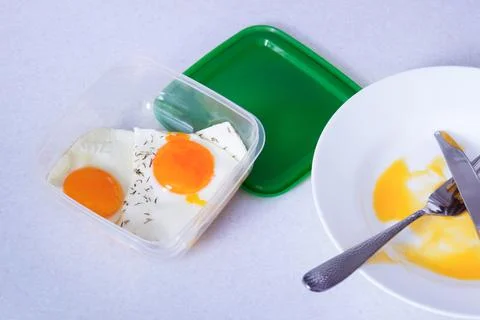 Scrambled eggs in a plastic container. leftover food for the future, food sav Stock Photos