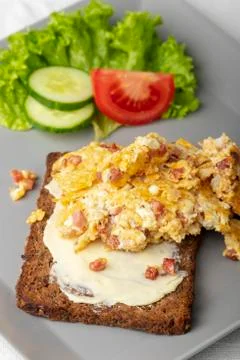 Scrambled eggs on a rye bread Stock Photos