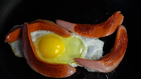 Scrambled eggs with sausage is fried in a pan Stock Footage 67895581