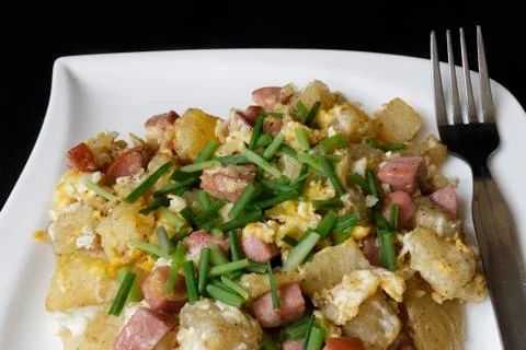 Scrambled eggs served with bits of salami Stock Photos