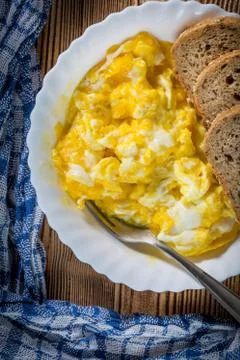 Scrambled eggs served with bread. Stock Photos
