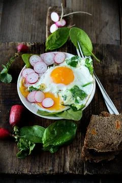 Scrambled eggs with spinach and radish food closeup Stock Photos