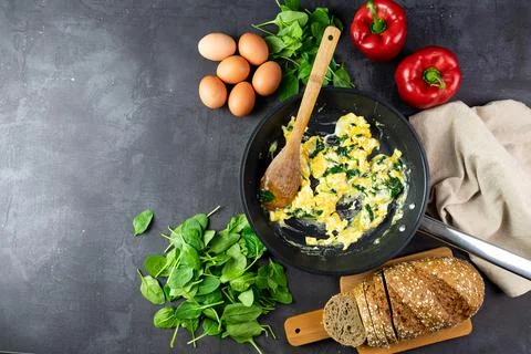 Scrambled eggs with spinach in a pan copy space Stock Photos