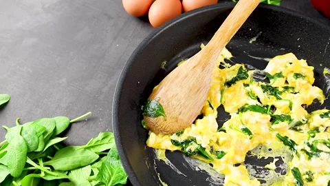 Scrambled eggs with spinach in a pan Stock Footage 145986897