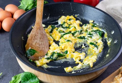Scrambled eggs with spinach in a pan Stock Photos