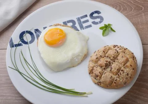 Scrambled eggs sunny side up on bread. Breakfast on a white plate. Stock Photos