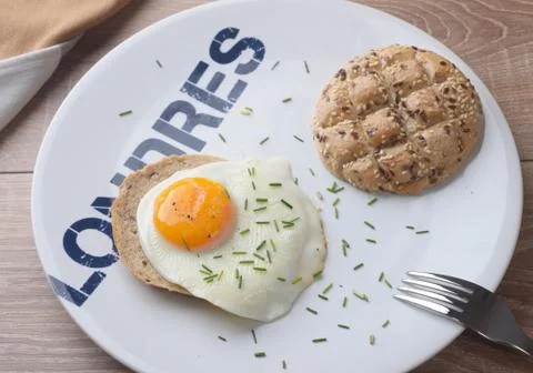 Scrambled eggs sunny side up on bread. Breakfast on a white plate. Stock Photos