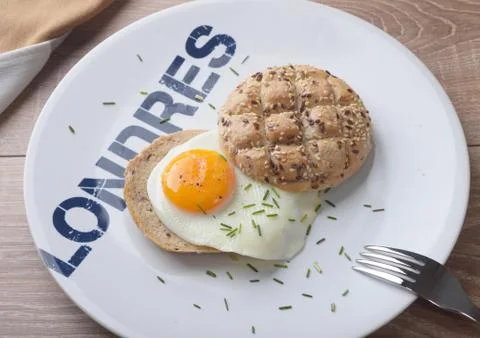 Scrambled eggs sunny side up on bread. Breakfast on a white plate. Stock Photos