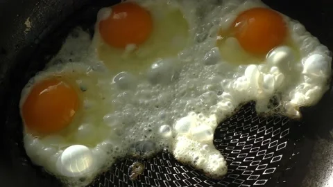 Scrambled eggs from three eggs are fried in a pan Stock Footage 162449026