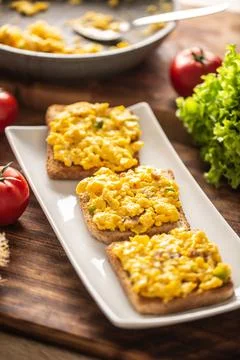 Scrambled eggs on toasts served on a plate Stock Photos