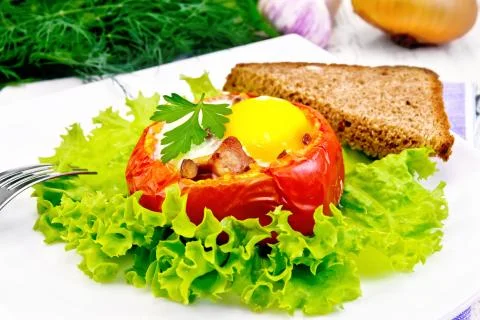 Scrambled eggs in tomato and bread on light board Stock Photos