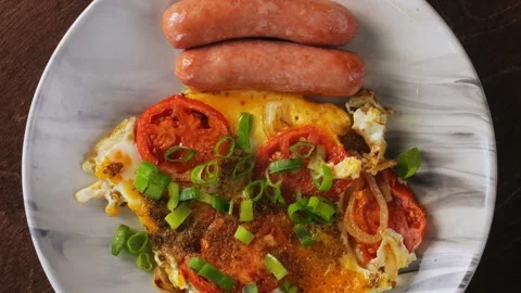 Scrambled eggs with tomatoes and fried sausages sprinkled with green onions.. Stock Footage 285071319