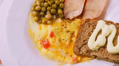 Scrambled eggs with tomatoes, bacon and green peas rotate in a circle 库存影片 270087178