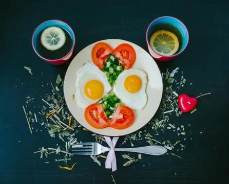 Scrambled eggs with tomatoes. Cup of tea Stock Photos