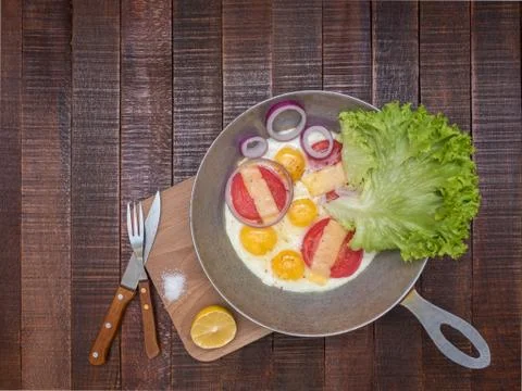 Scrambled eggs with vegetables and cheese on a wooden table. Stock Photos