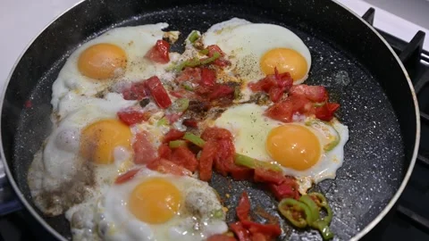 Scrambled eggs with vegetables frying on a pan Видео 253828121