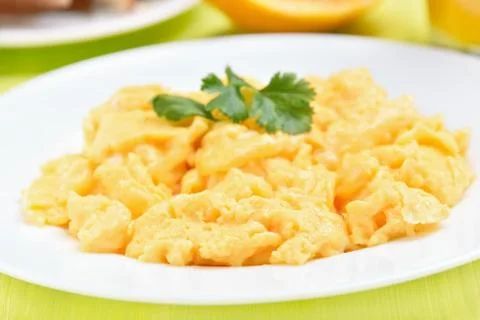 Scrambled eggs on white plate Stock-Fotos