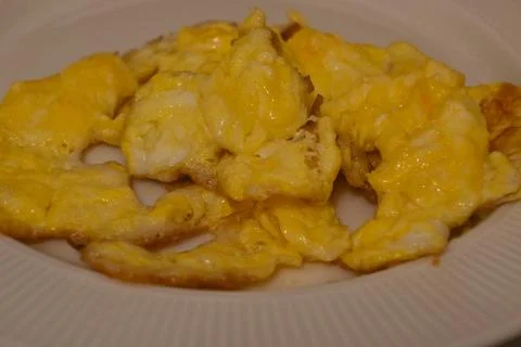 Scrambled eggs on a white plate Stock Photos