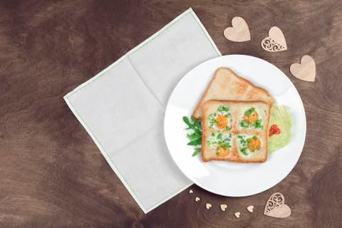 Scrambled fried eggs and bread in the shape of a heart with hot toasts Stock Photos