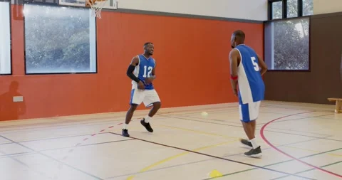 Scrambling for ball as pass bouncing african american teammates drilling at gym, Видео 337536897