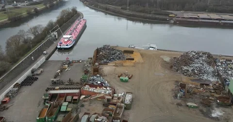 Scrap Yard By Canal With Moored Tanker Barge And Skips, Calm Water, Aerial View Stock-Footage 340645908