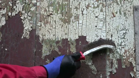 Scrape old aged paint from wooden house wall plank with metal brush Stockbeeldmateriaal 28394774