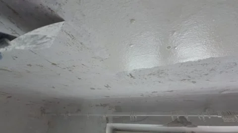 Scrape off old paint from ceiling using putty knife. Stock Footage 270902514