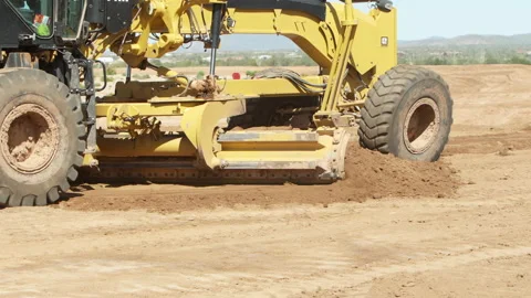 Scraper, land mover, grades the dirt to grade the ground for building houses Stock Footage 217540167