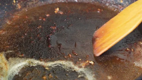 Scraping burnt fat from surface of pan after frying. Stock Footage 292758877