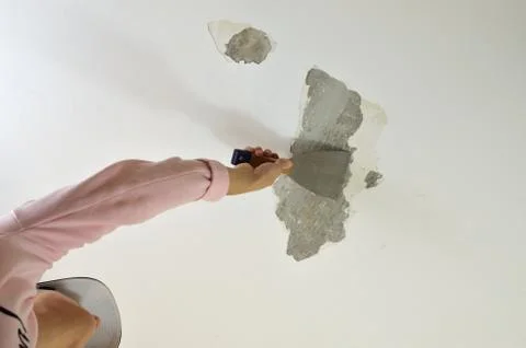 Scraping a Ceiling with a Tool Stock Photos