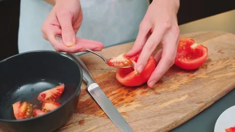 Scraping the core of a tomato with a spoon Stock-Footage 249701536