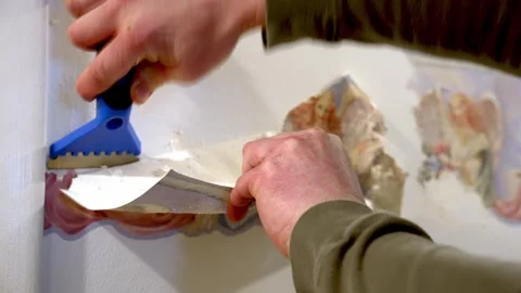 Scraping off decorative wallpaper border during home improvement project Stock Footage 306226299