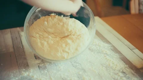 Scraping dough out of bowl with scraper close up, removing fermented pastry to Stock Footage 338039614