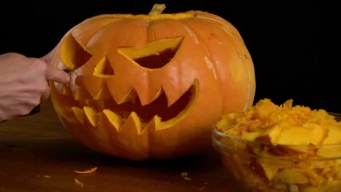 Scraping fresh pumpkin while making a lantern. Preparation of paraphernalia f Stock Footage 272459967