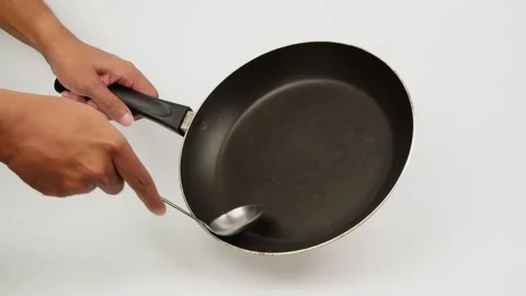 Scraping a Frying Pan with a Large Spoon Stock Footage 327851968