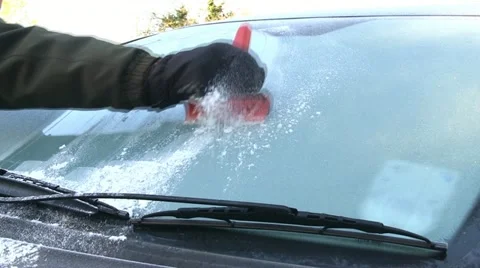 Scraping ice off a car windscreen Stock Footage 12672526