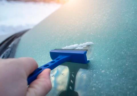 Scraping ice from a car windscreen Stock Photos