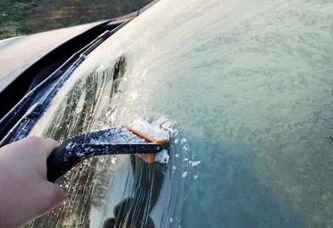 Scraping the ice from windshield of the car 写真素材
